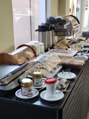 a buffet line with pastries and coffee on plates at Pousada Litorânea in São Luís