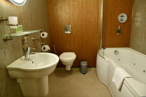 a bathroom with a sink and a tub and a toilet at The Knighton Hotel in Knighton