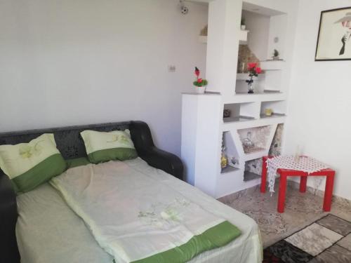 a bedroom with a bed and a red stool at Casa Ana in Eforie Sud