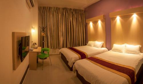 a hotel room with two beds and a television at Avantgarde Hotel in Skudai