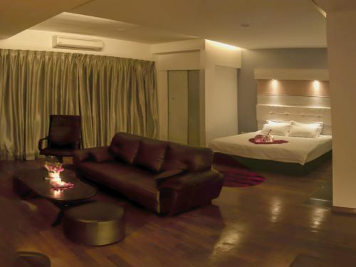ein Hotelzimmer mit einem Bett und einem Ledersofa in der Unterkunft Avantgarde Hotel in Skudai