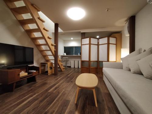 a living room with a couch and a tv at Private house En Sagisu #OF1 in Osaka