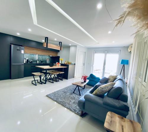 a living room with a blue couch and a table at Aqua Blue Lakeview Apartment Ohrid in Peštani