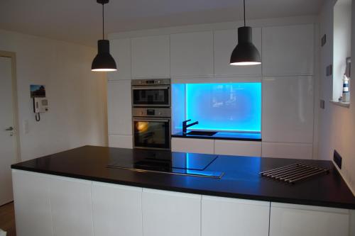 eine Küche mit einer Arbeitsplatte mit blauem Bildschirm in der Unterkunft Résidence Château Angélus in De Haan