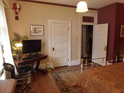 a bedroom with a bed and a desk with a computer at Auberge King Edward Bed and Breakfast in Ottawa