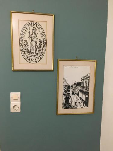 two framed pictures hanging on a wall at Hotel George in Kalamata