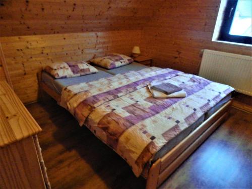 ein Schlafzimmer mit einem großen Bett in einem Blockhaus in der Unterkunft Chata Roubenka - Jesenka in Dolní Moravice
