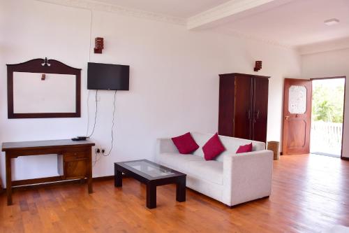 ein Wohnzimmer mit Couch und Tisch in der Unterkunft Hotel Nadee in Aluthgama