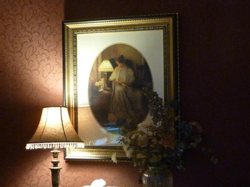a picture of a woman in a mirror next to a lamp at Auberge King Edward Bed and Breakfast in Ottawa