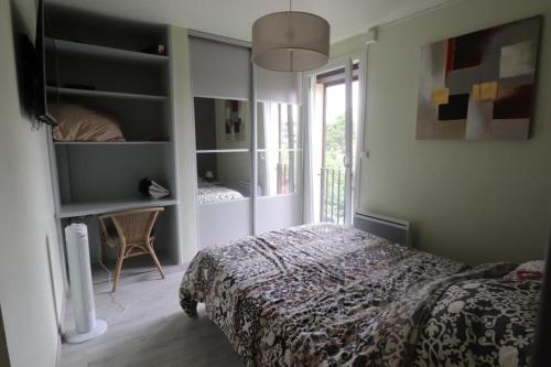 a bedroom with a bed and a large window at SOLEIL 4 ét in Saint-Cyprien-Plage