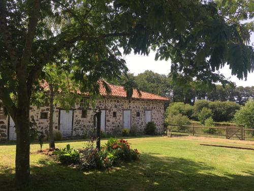 Pressacにある"La Maison de Villars" au coeur de la natureの庭木のある古い石造りの家