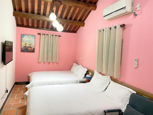 two beds in a room with pink walls at Xinqin B&B - City Area in Jincheng