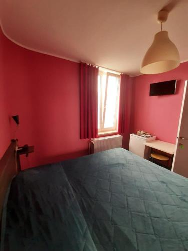 a bedroom with red walls and a large bed at hotel Melissa in Péruwelz