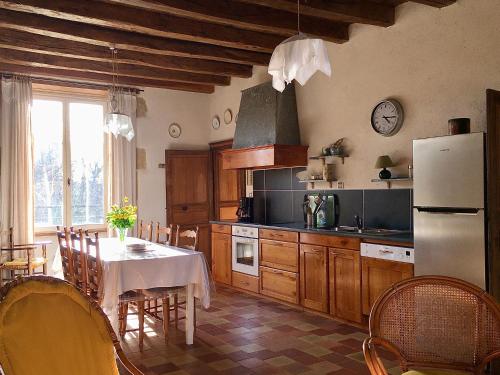 a kitchen with a table and a refrigerator at "La Maison de Villars" au coeur de la nature in Pressac