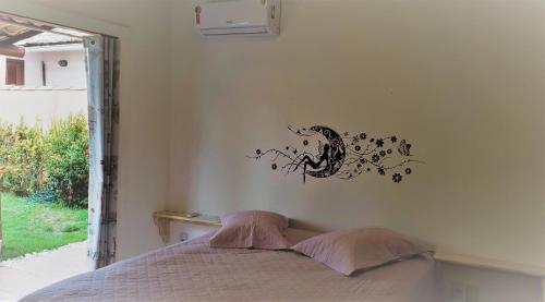 um quarto com uma cama com um autocolante na parede em Karina Estudio na Praia do Forte