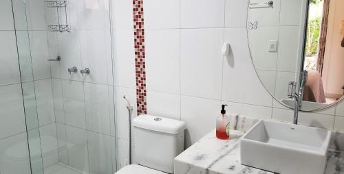 y baño con ducha, aseo y lavamanos. en Karina Estudio, en Praia do Forte
