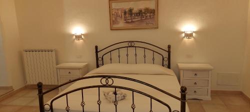 a bedroom with a bed with two night stands and two lights at Domo Antiga Guest Rooms in Sorso