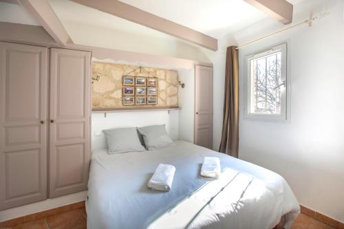 a bedroom with a white bed with two towels on it at Mas Saint Antoine in Bourg-Saint-Andéol
