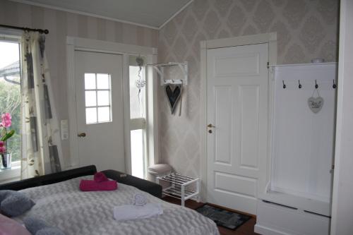 Huset på hauen في Volda: غرفة نوم مع سرير وفوط وردية عليه