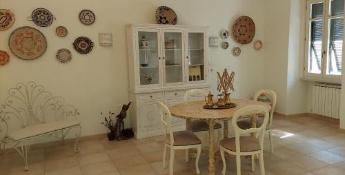 a dining room with a table and chairs and plates on the wall at Domo Antiga Guest Rooms in Sorso