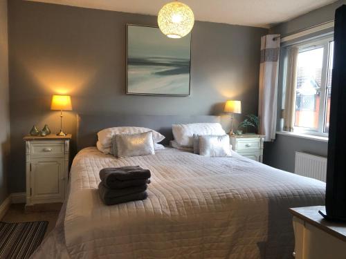 a bedroom with a large bed with two pillows at 2 The Mews in Winsford