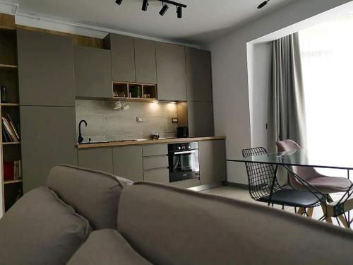 uma sala de estar com um sofá, uma mesa e uma cozinha em 49 Apartment em Mamaia Nord – Năvodari