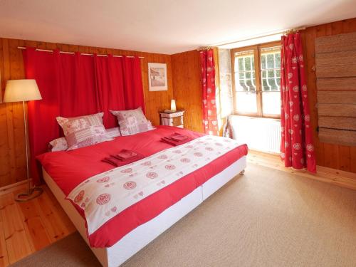 een slaapkamer met een bed met rode gordijnen en een raam bij Domaine de Bellevue Gîte du Mont Poupet in Marnoz