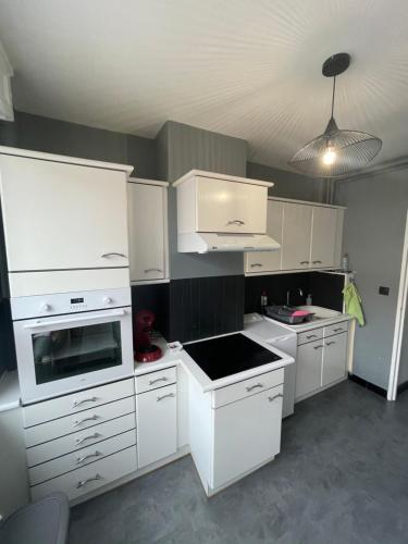 une cuisine avec des comptoirs et des placards blancs dans l'établissement Literie Haut de gamme entre gare et centre ville, à Dunkerque