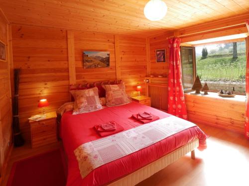 a bedroom with a bed in a log cabin at Domaine de Bellevue Gîte du Mont Begon in Marnoz