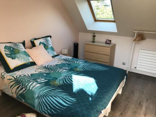 a bedroom with a bed with a green comforter at Studio T1BIS BORD DE PLAGE in Saint-Lunaire