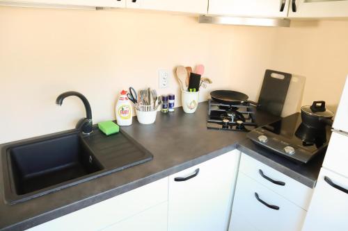 a kitchen counter with a sink and a stove at Maria Apartment Rootsi 9 in Kuressaare