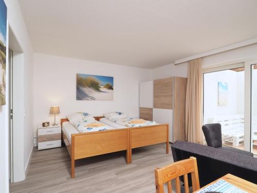 a bedroom with a bed and a desk in a room at Apartmenthaus Jasmin in Büsum