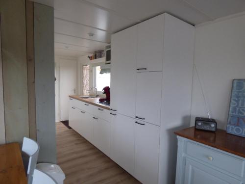 比倫的住宿－Chalet Seazon O1，厨房配有白色橱柜和台面