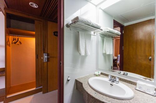 V.L. Hatyai Hotel في هات ياي: حمام مع حوض ومرآة