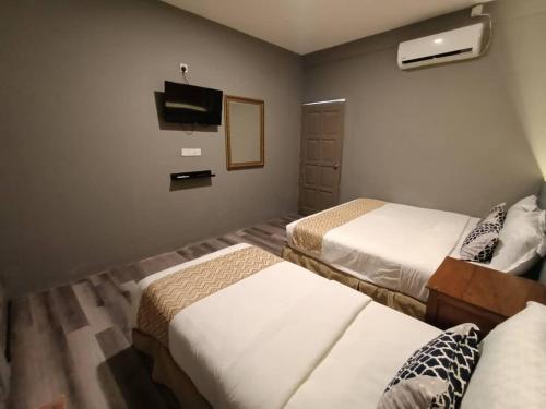 a hotel room with two beds and a flat screen tv at Tc theme park Guest house in Kuantan