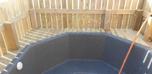 a hot tub with a mop in the middle at Hvammur 4 with private hot tub (Fagurgali) in Drangsnes