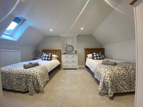 a attic bedroom with two beds and a window at The Cottage in Pembrokeshire