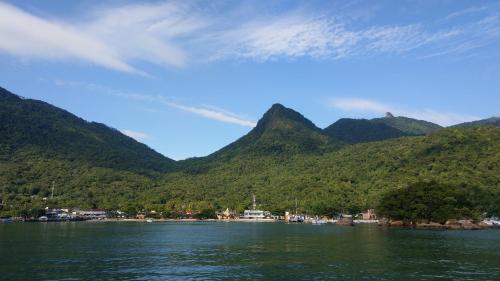 a large body of water with mountains in the background at Mi Casa Su Casa Lofts in Abraão