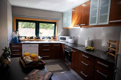 eine Küche mit Holzschränken und einer Arbeitsplatte in der Unterkunft BlancoHouse. fozdodouro in Porto