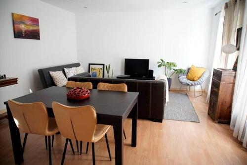 a living room with a black table and chairs at BlancoHouse. fozdodouro in Porto