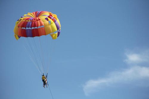 a person flying a parachute in the sky at Turi Beach Resort in Nongsa