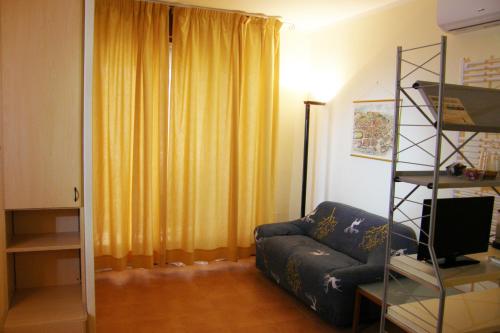 uma sala de estar com um sofá e uma cortina amarela em I Borghi em Empoli