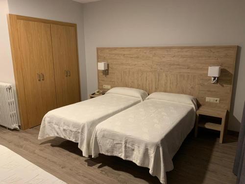 a hotel room with two beds and a cabinet at Hotel Bellavista in Bellver de Cerdanya 
