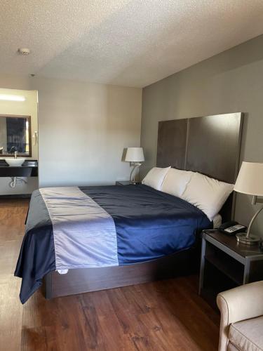 a bedroom with a large bed with a blue blanket at Stockbridge Inn in Stockbridge