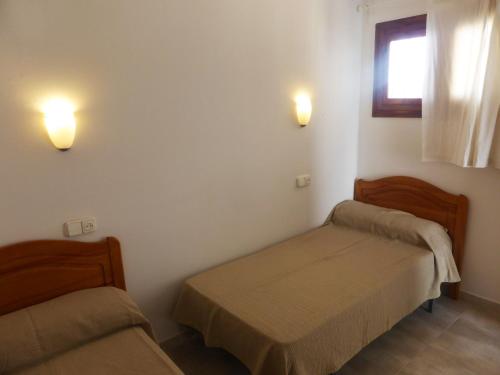 a room with two beds and two lights on the wall at Ático a 100 metros de la playa in Cullera