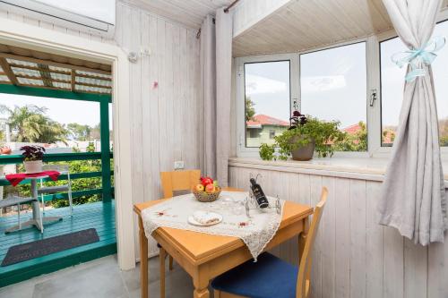 a table and chairs on the porch of a house at Leyad Hashmura Lodging in Yesod Hamaala