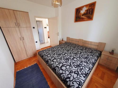 a bedroom with a bed with a black and white comforter at Szekrény Apartman in Lenti