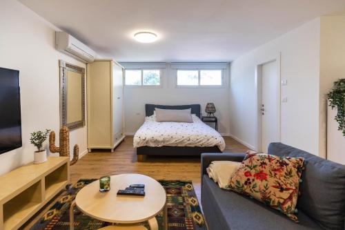 uma sala de estar com um sofá e uma cama em Sheba-Shik apartment, Tel hashomer שיבא-שיק, תל השומר,דירת סטודיו מקסימה! em Ramat Gan