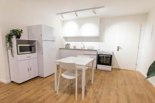 a white kitchen with a table and a refrigerator at Sheba-Shik apartment, Tel hashomer שיבא-שיק, תל השומר,דירת סטודיו מקסימה! in Ramat Gan