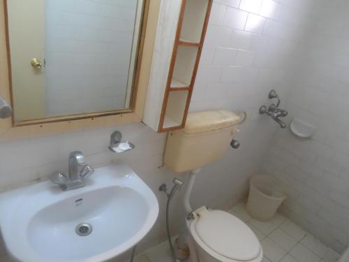 a bathroom with a sink and a toilet and a mirror at Shanthiniketan - Ramoji Film City in Pedda Ambarpet